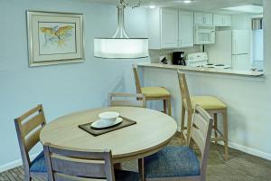 奥兰多Club Wyndham Orlando International的厨房以及带桌椅的用餐室。