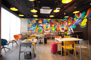 波哥大ibis budget Bogota Marly的餐厅设有桌椅和色彩缤纷的墙壁