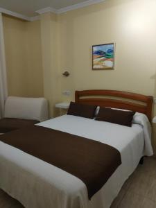 卡马里尼亚斯斯黛拉德玛尔旅馆的一间卧室配有一张大床和一把椅子