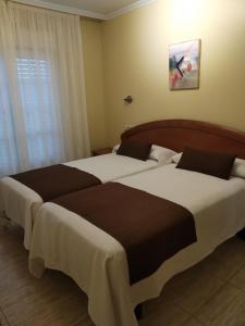 卡马里尼亚斯斯黛拉德玛尔旅馆的配有窗户的酒店客房内的两张床