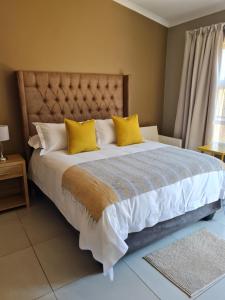 勒斯滕堡Village Kulture - Guest House的一间卧室配有一张带黄色枕头的大床