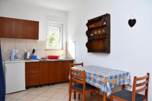 班约勒apartmani Novotny plavi的厨房配有桌子和桌椅