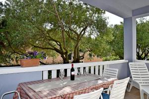 班约勒apartmani Novotny plavi的阳台上的桌子和一瓶葡萄酒