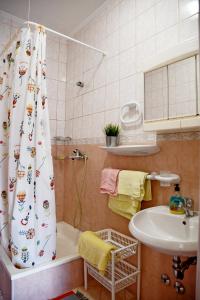 班约勒apartmani Novotny plavi的浴室配有淋浴帘和盥洗盆。