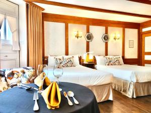 魁北克市皮埃尔别墅酒店的酒店客房设有两张床和一张带葡萄酒杯的桌子。
