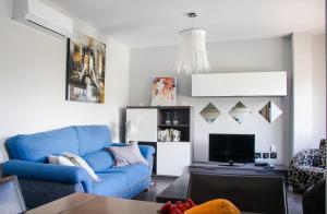 厄尔梅达诺Apartments Alba的客厅配有蓝色的沙发和电视