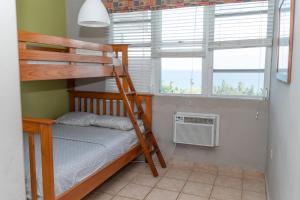 毛纳沃Apartment in Villas Del Faro Resort with WIFI的一间卧室配有双层床和2个窗户。