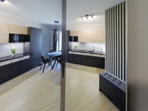 波兹南Apartament Malta Poznań的厨房配有黑色橱柜和餐桌