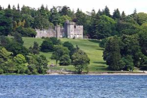 亚历山德里亚One bedroom Flat on the banks of Loch Lomond的一座城堡,位于湖畔的山顶上