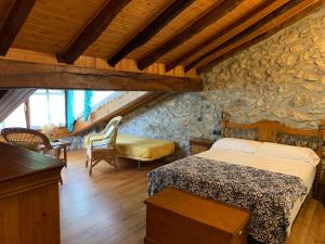 戈特赫斯阿特亚加乌雷斯蒂乡村民宿的一间卧室设有一张床和石墙