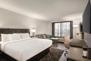 多森La Quinta inn & suites by Wyndham Dothan的酒店客房设有一张大床和一间客厅。