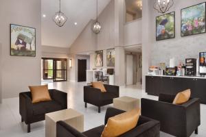 多森La Quinta inn & suites by Wyndham Dothan的大堂配有沙发、椅子和柜台