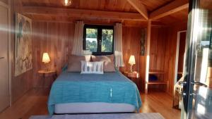孔波尔塔Ying Yang Monte da Lua的卧室配有一张床铺,位于带木墙的房间内