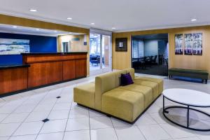 安大略SureStay Hotel by Best Western Ontario Airport的带沙发和桌子的等候室