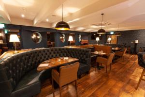 伦敦德里贝斯特韦斯特白马酒店的餐厅设有皮革沙发、桌子和椅子
