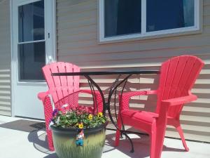Brook ParkBeach Mirage Suites的两张红色的椅子和一张带花盆的桌子