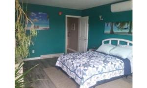 Brook ParkBeach Mirage Suites的一间卧室设有一张床和绿色的墙壁