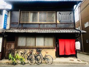 京都Guesthouse KYOTO COMPASS的停在大楼前的一群自行车