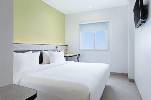 打横Amaris Hotel Tasikmalaya的窗户客房内的一张白色床