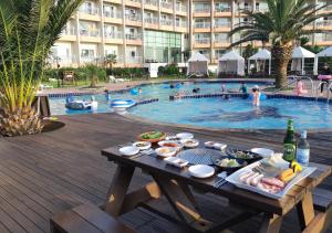 济州市蓝色夏威夷酒店的游泳池前的餐桌,供应食物和饮料
