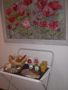 胡法利兹乌尔特住宿加早餐旅馆的一张桌子,上面有面包和一幅红色花卉画