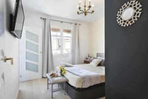 巴塞罗那Apartment Leonor的一间卧室配有一张床、镜子和吊灯