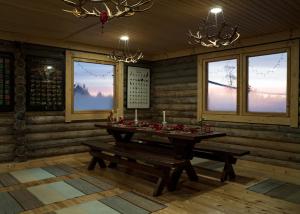 锡尔卡Polar Lights Lodge的一间带桌子、长凳和窗户的用餐室