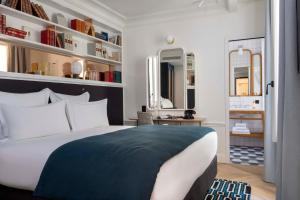 巴黎卢浮蒙大拿酒店的一间卧室配有一张大床和书架