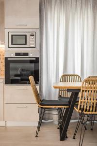 阿尔戈斯托利翁Serenity Home的厨房配有桌子、两把椅子和微波炉