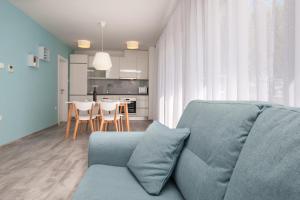 波尔Apartments Dva Galeba的一间带蓝色沙发的客厅和一间厨房