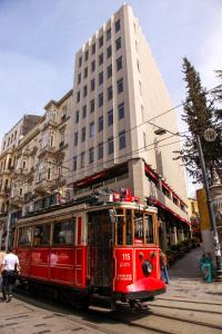 伊斯坦布尔Taksim Seya Suites Hotel的大楼前的一条街道上的红色推车