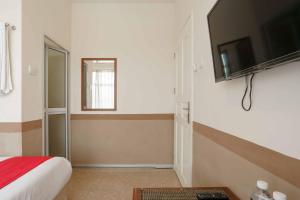 巴淡岛中心RedDoorz near Plaza Botania 1 Batam的一间卧室配有一张床,墙上配有电视