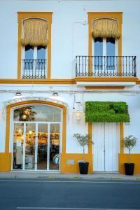 阿亚蒙特DONDE DUERME EL GUADIANA的街上有两扇窗户和两株植物的建筑