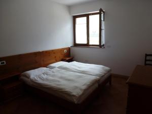 阿科Agritur Maso Fontane的卧室配有白色的床和窗户