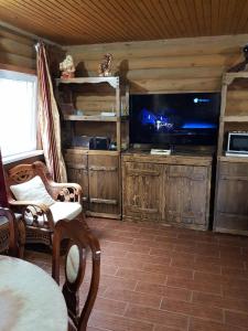 TroitskoyeЗагородный дом , сруб , рыбалка , баня , отдых , река , лес的客厅配有平面电视和桌子。