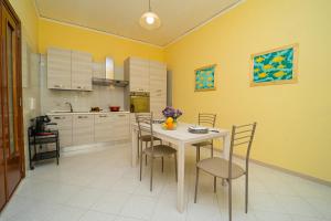 阿特拉尼Ada's House的厨房配有桌椅和黄色墙壁