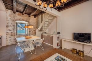 科托尔18th Century Villa in the UNESCO Bay of Kotor的厨房以及带桌椅的用餐室。