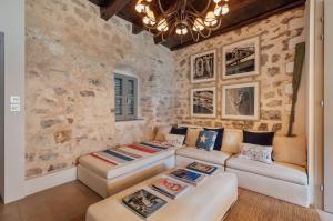 科托尔18th Century Villa in the UNESCO Bay of Kotor的客厅设有两张沙发和一堵石墙