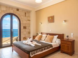 科林瓦里奥Xristinas Seaside Apartments的一间卧室设有一张床和一个大窗户