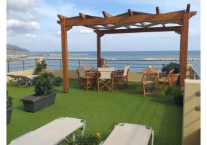 科林瓦里奥Xristinas Seaside Apartments的一个带桌椅的庭院和大海