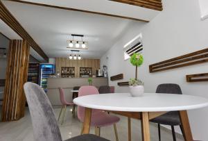 阿尔杰什河畔库尔泰亚Casa Sima的一间配备有白色桌椅的用餐室