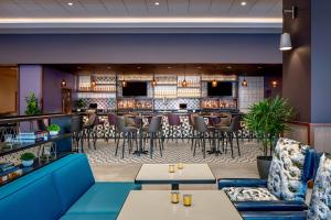 坦帕Hyatt House Tampa Downtown的一间带桌椅的餐厅和一间酒吧