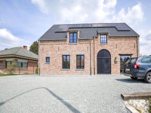 龙塞Beautiful house in Flemish Ardennes for cyclists的屋顶上设有太阳能电池板的砖屋