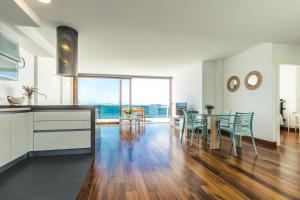 梅莱纳拉Top Views Melenara Beach Avenue Apartments的厨房以及带桌椅的用餐室。