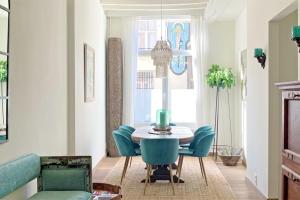 安特卫普Rosier37的一间带桌子和蓝色椅子的用餐室