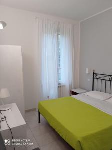 克里日亚Cecio 5 Terre Rooms的一间卧室设有一张绿色的床和一个窗户。