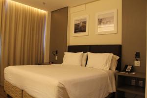 戈亚尼亚Holiday Inn - Goiania, an IHG Hotel的卧室配有一张带白色床单和枕头的大床。