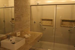 戈亚尼亚Holiday Inn - Goiania, an IHG Hotel的一间带水槽和玻璃淋浴的浴室