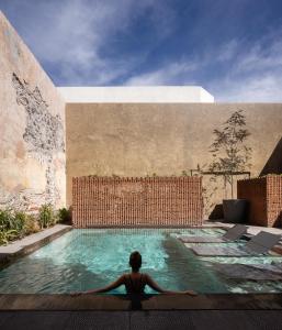 克雷塔罗Tá Hotel de diseño的一个人坐在游泳池里