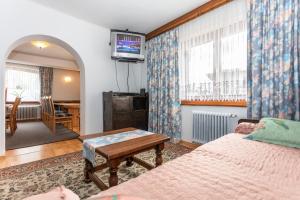 布鲁克安德格罗斯哥Ferienhaus Alpenrose的一间卧室配有一张床、一张桌子和一台电视。